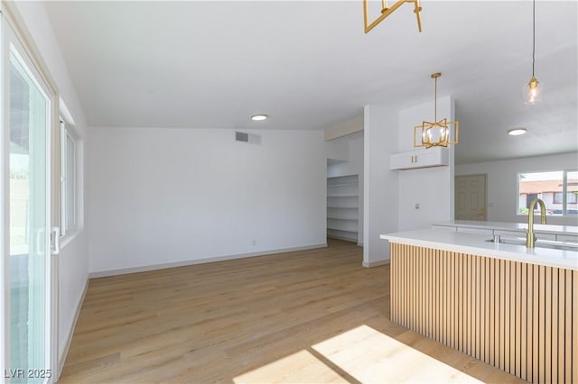 6760 Fallona Ave, Las Vegas, NV 89156 - kitchen with light wood-style floors, light countertops, decorative light fixtures, a chandelier, and recessed lighting