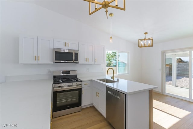 6760 Fallona Ave, Las Vegas, NV 89156 - kitchen with a chandelier, stainless steel appliances, a peninsula, light wood-type flooring, and vaulted ceiling