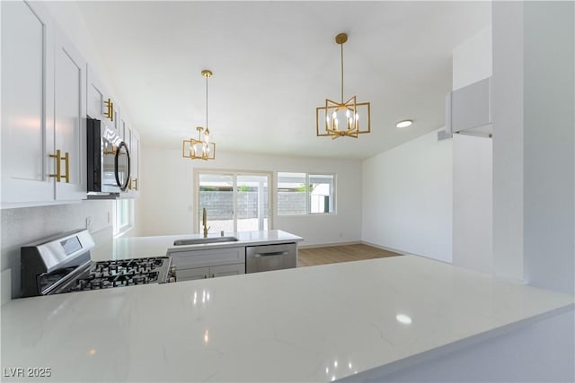 6760 Fallona Ave, Las Vegas, NV 89156 - kitchen featuring a chandelier, stainless steel appliances, light wood-type flooring, and decorative light fixtures