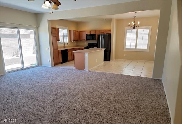 2648 Blairgowrie Dr, Henderson, NV 89044 - kitchen with ceiling fan, black appliances, a kitchen island, and light carpet