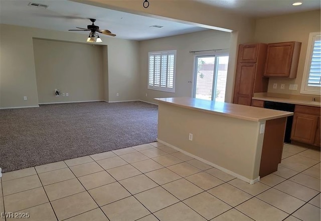 2648 Blairgowrie Dr, Henderson, NV 89044 - kitchen with light countertops, light carpet, a ceiling fan, dishwashing machine, and light tile patterned floors