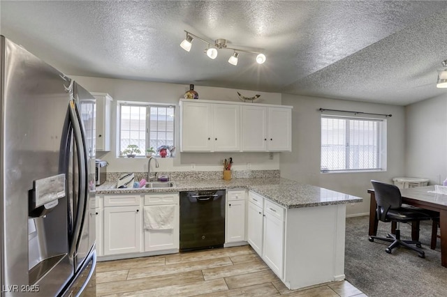 729 Concrete Ct, Las Vegas, NV 89110 - kitchen with stainless steel fridge, a textured ceiling, a peninsula, black dishwasher, and white cabinets