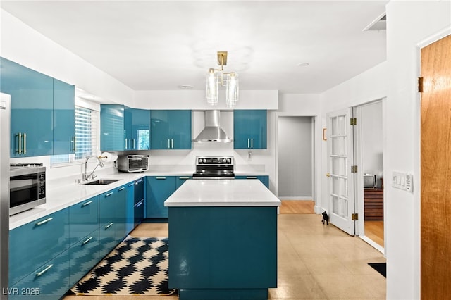 639 Lacy Ln, Las Vegas, NV 89107 - kitchen with blue cabinets, a center island, stainless steel microwave, light countertops, and wall chimney exhaust hood