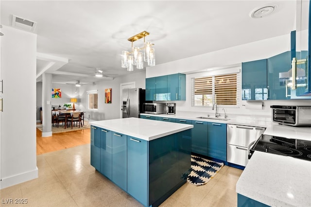 639 Lacy Ln, Las Vegas, NV 89107 - kitchen with blue cabinetry, stainless steel appliances, light countertops, and a center island