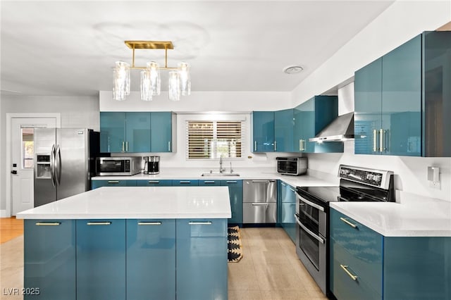 639 Lacy Ln, Las Vegas, NV 89107 - kitchen featuring blue cabinetry, appliances with stainless steel finishes, a kitchen island, hanging light fixtures, and light countertops
