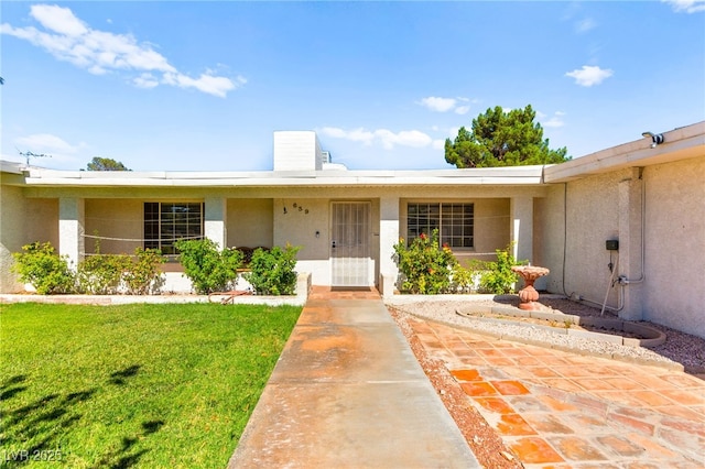 639 Lacy Ln, Las Vegas, NV 89107 - view of exterior entry with stucco siding and a yard