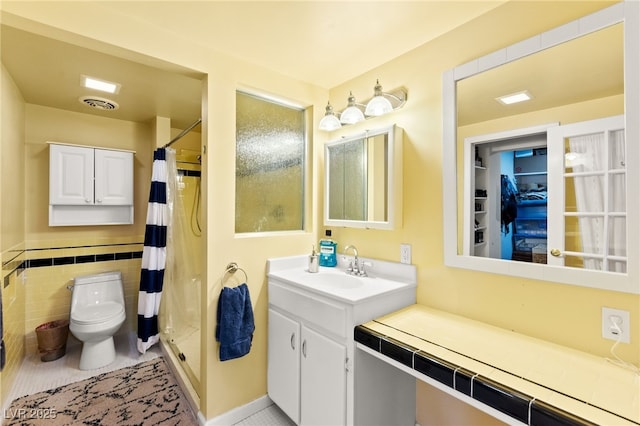 639 Lacy Ln, Las Vegas, NV 89107 - full bathroom featuring a shower with shower curtain, vanity, tile patterned floors, and tile walls