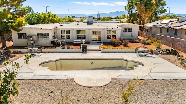 639 Lacy Ln, Las Vegas, NV 89107 - rear view of property featuring a mountain view, a patio, an empty pool, and stucco siding