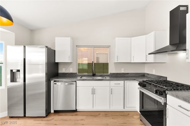1904 Leaning Pine Way, Las Vegas, NV 89128 - kitchen featuring appliances with stainless steel finishes, wall chimney exhaust hood, white cabinetry, light wood-style flooring, and dark countertops