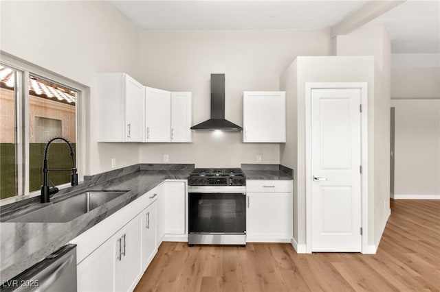 1904 Leaning Pine Way, Las Vegas, NV 89128 - kitchen with stainless steel appliances, wall chimney range hood, light wood-type flooring, white cabinetry, and dark stone countertops