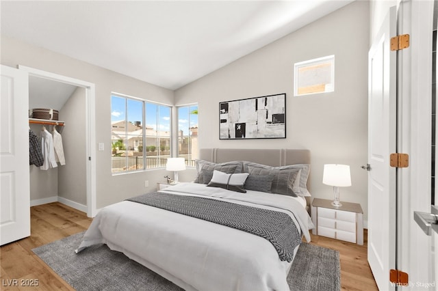 1904 Leaning Pine Way, Las Vegas, NV 89128 - bedroom featuring vaulted ceiling, light wood-type flooring, and a walk in closet