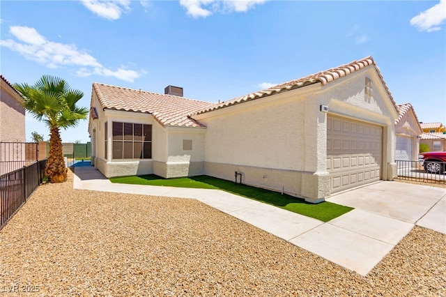 1904 Leaning Pine Way, Las Vegas, NV 89128 - view of side of property featuring stucco siding, a tile roof, a garage, concrete driveway, and a chimney