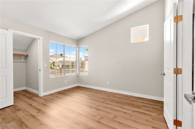 1904 Leaning Pine Way, Las Vegas, NV 89128 - unfurnished bedroom featuring light wood-style floors, lofted ceiling, and a walk in closet