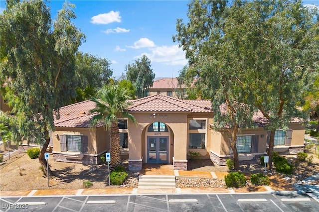 2060 Rancho Lake Dr Unit 103, Las Vegas, NV 89108 - mediterranean / spanish house with french doors, uncovered parking, stucco siding, a tiled roof, and stone siding