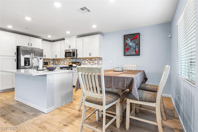 906 Cadence View Way, Henderson, NV 89011 - kitchen featuring stainless steel appliances, light wood finished floors, tasteful backsplash, white cabinetry, and recessed lighting