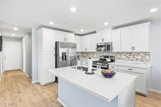 906 Cadence View Way, Henderson, NV 89011 - kitchen featuring stainless steel appliances, white cabinetry, light wood-style flooring, backsplash, and recessed lighting
