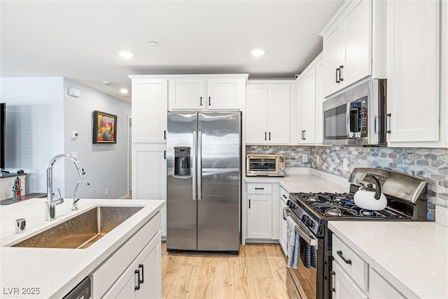 906 Cadence View Way, Henderson, NV 89011 - kitchen featuring stainless steel appliances, light wood-style flooring, white cabinets, backsplash, and recessed lighting
