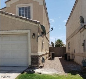 3254 Gold Run St, North Las Vegas, NV 89032 - view of side of property featuring a garage, stucco siding, and stone siding