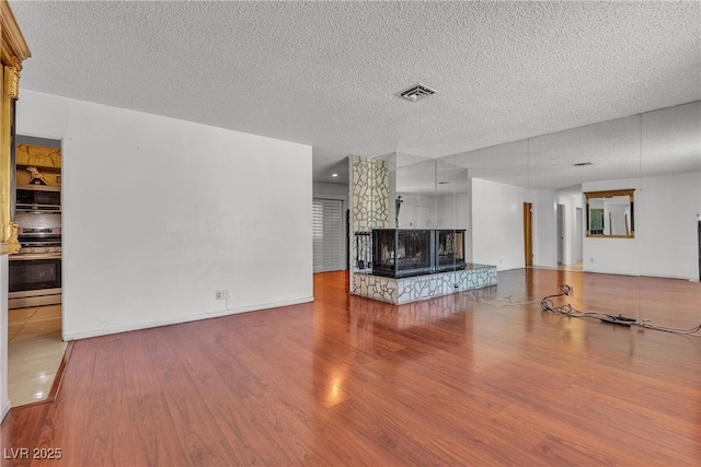 4709 Alpine Pl, Las Vegas, NV 89107 - living room with wood finished floors, a textured ceiling, and a fireplace