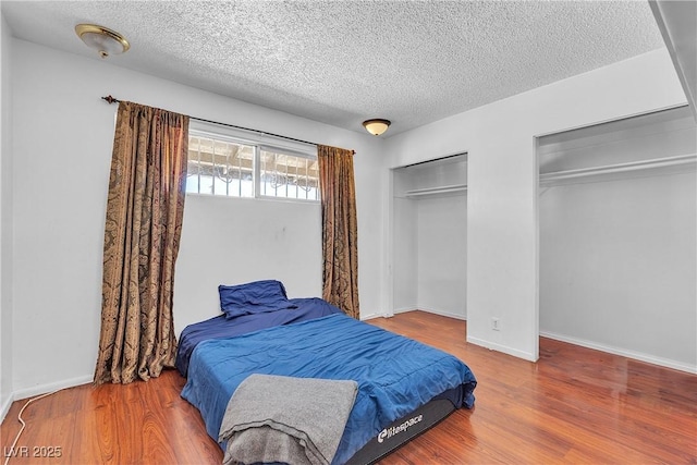 4709 Alpine Pl, Las Vegas, NV 89107 - bedroom with multiple closets, a textured ceiling, and wood finished floors