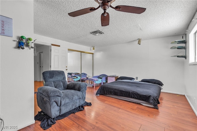 4709 Alpine Pl, Las Vegas, NV 89107 - bedroom with a textured ceiling, wood finished floors, a closet, and ceiling fan