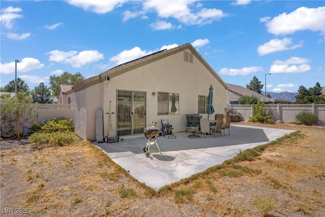 5630 Midnight Breeze St, North Las Vegas, NV 89081 - rear view of house featuring a patio, a fenced backyard, and stucco siding