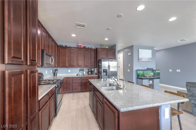 8104 Switchback Run St, Las Vegas, NV 89166 - kitchen featuring stainless steel appliances, a kitchen breakfast bar, light wood-style flooring, recessed lighting, and light stone countertops