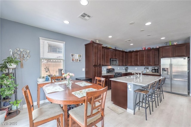 8104 Switchback Run St, Las Vegas, NV 89166 - kitchen with appliances with stainless steel finishes, recessed lighting, a kitchen island with sink, a breakfast bar area, and light wood-type flooring