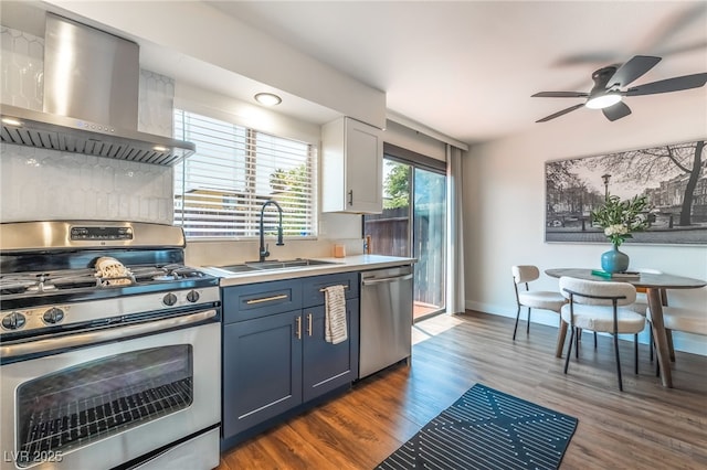 1467 Hialeah Dr Unit C, Las Vegas, NV 89119 - kitchen featuring stainless steel appliances, wall chimney range hood, dark wood-type flooring, ceiling fan, and light countertops