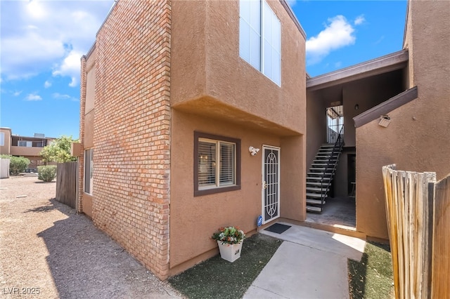 1467 Hialeah Dr Unit C, Las Vegas, NV 89119 - view of side of home featuring stucco siding, brick siding, and stairs