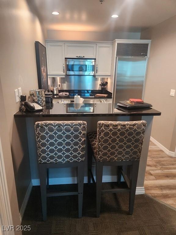 135 E Harmon Ave Unit 2621, Las Vegas, NV 89109 - bar with stainless steel appliances, light wood-style floors, and recessed lighting