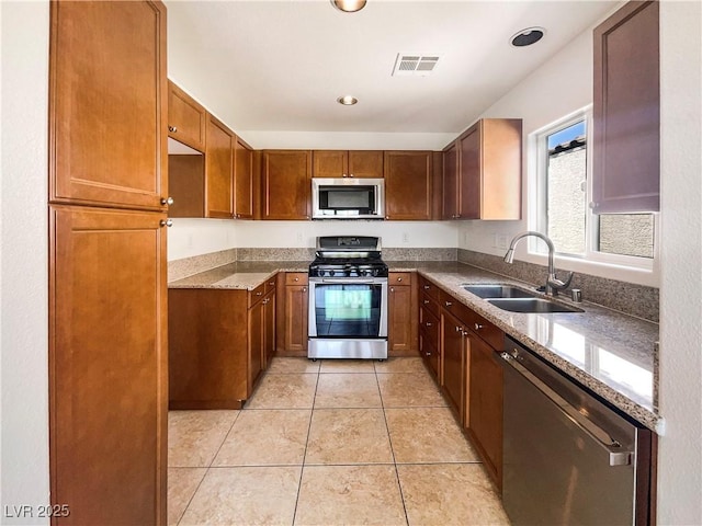 8872 Niche Ave, Las Vegas, NV 89149 - kitchen featuring stainless steel appliances, brown cabinetry, light tile patterned floors, light stone counters, and recessed lighting