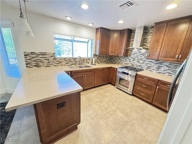 2406 Showcase Dr, Las Vegas, NV 89134 - kitchen featuring a peninsula, high end range, wall chimney exhaust hood, backsplash, and pendant lighting