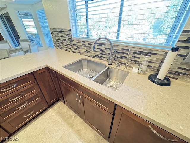 2406 Showcase Dr, Las Vegas, NV 89134 - kitchen featuring backsplash, light stone counters, and a peninsula