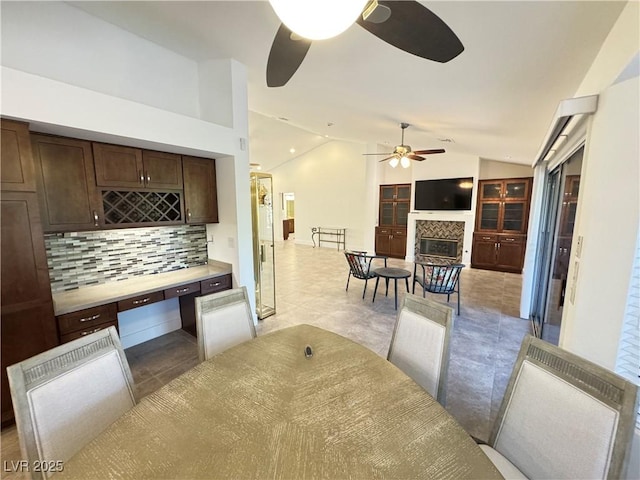 2406 Showcase Dr, Las Vegas, NV 89134 - dining room featuring ceiling fan, vaulted ceiling, and a tile fireplace