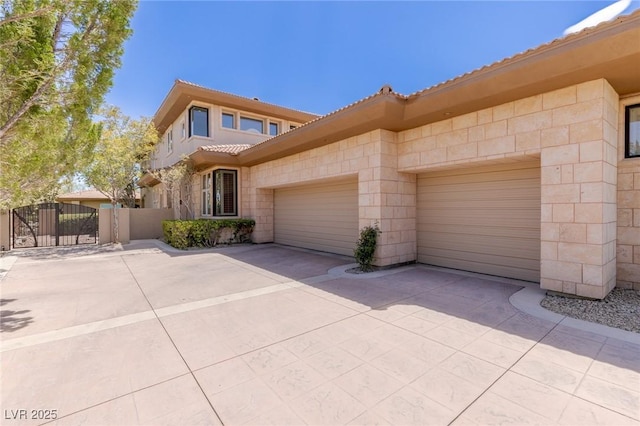 9801 Orient Express Ct, Las Vegas, NV 89145 - mediterranean / spanish home featuring a tile roof, a garage, concrete driveway, and a gate