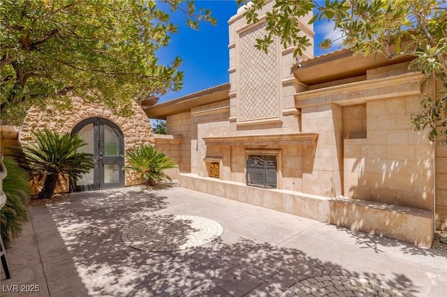 9801 Orient Express Ct, Las Vegas, NV 89145 - view of patio / terrace featuring a tile fireplace and french doors
