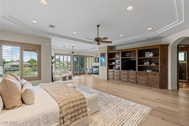 9801 Orient Express Ct, Las Vegas, NV 89145 - bedroom featuring arched walkways, a fireplace, light wood finished floors, and recessed lighting