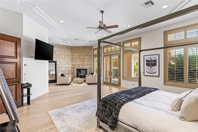9801 Orient Express Ct, Las Vegas, NV 89145 - bedroom featuring recessed lighting, light wood-type flooring, a glass covered fireplace, and access to exterior