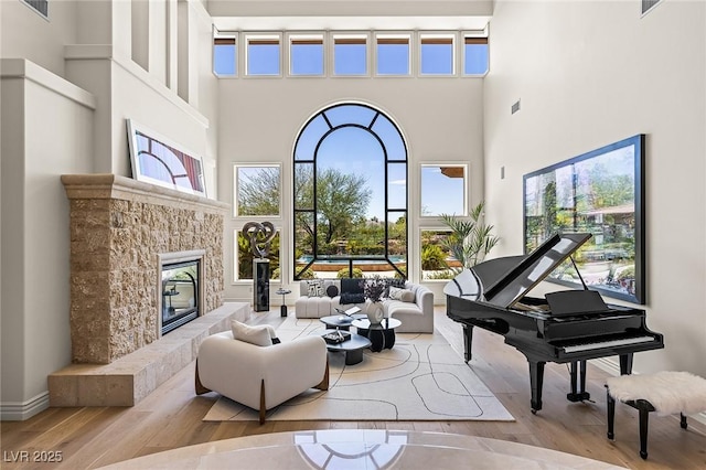 9801 Orient Express Ct, Las Vegas, NV 89145 - living room featuring a high ceiling, wood finished floors, a fireplace, and healthy amount of natural light