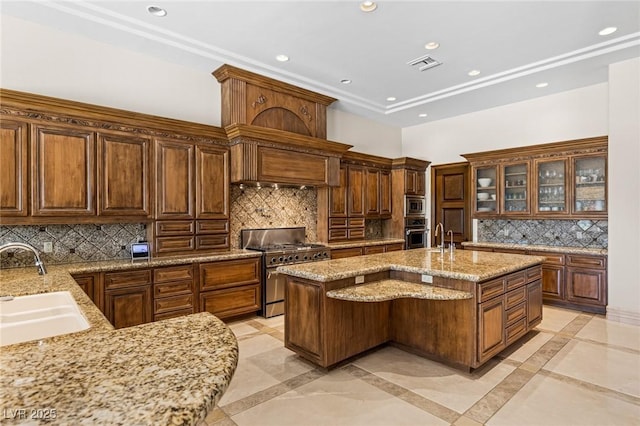 9801 Orient Express Ct, Las Vegas, NV 89145 - kitchen with inlaid floor details, recessed lighting, appliances with stainless steel finishes, tasteful backsplash, and light stone countertops