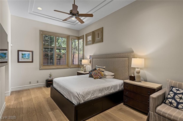 9801 Orient Express Ct, Las Vegas, NV 89145 - bedroom with light wood-type flooring, a tray ceiling, and a ceiling fan