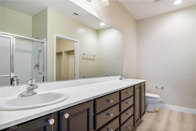 2563 Sargon St, Henderson, NV 89044 - bathroom featuring double vanity, wood finished floors, a shower stall, a walk in closet, and recessed lighting