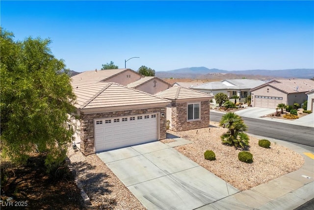 2563 Sargon St, Henderson, NV 89044 - ranch-style house featuring stone siding, a garage, driveway, and a tile roof