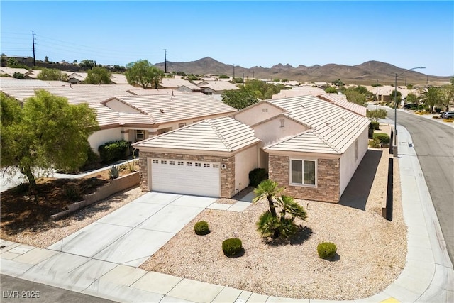 2563 Sargon St, Henderson, NV 89044 - ranch-style home featuring an attached garage, stone siding, a mountain view, stucco siding, and concrete driveway