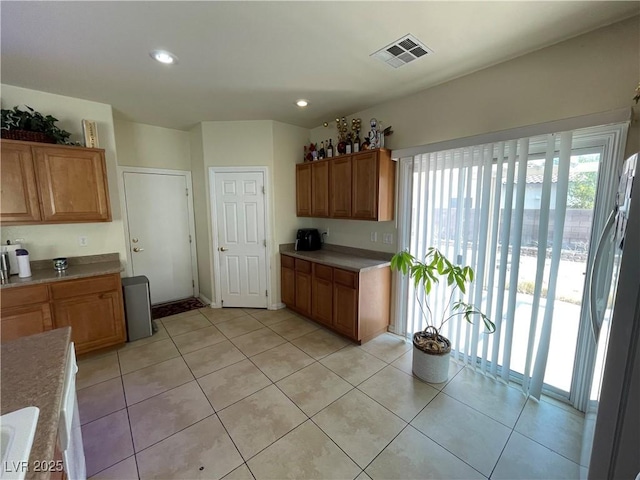 5625 Fast Payout Ct, Las Vegas, NV 89122 - kitchen featuring freestanding refrigerator, brown cabinets, light countertops, light tile patterned flooring, and recessed lighting