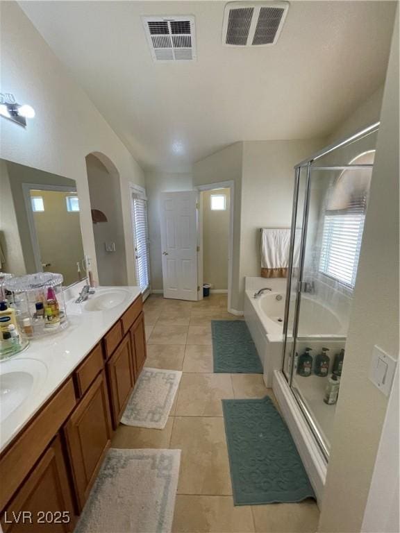 5625 Fast Payout Ct, Las Vegas, NV 89122 - full bathroom featuring lofted ceiling, a bath, tile patterned flooring, a shower stall, and double vanity