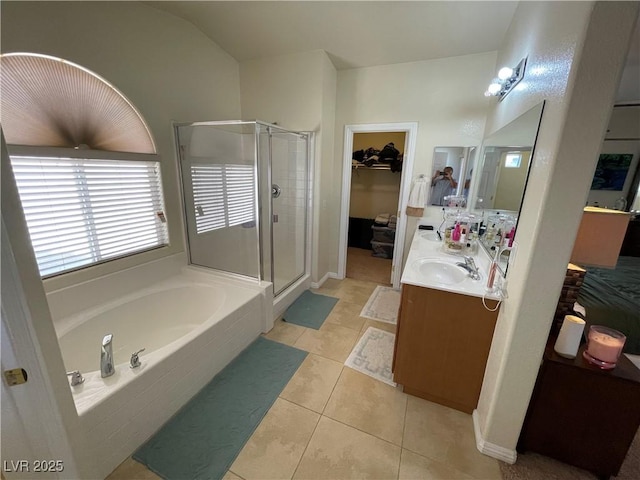 5625 Fast Payout Ct, Las Vegas, NV 89122 - bathroom featuring a shower stall, a walk in closet, a garden tub, double vanity, and tile patterned floors