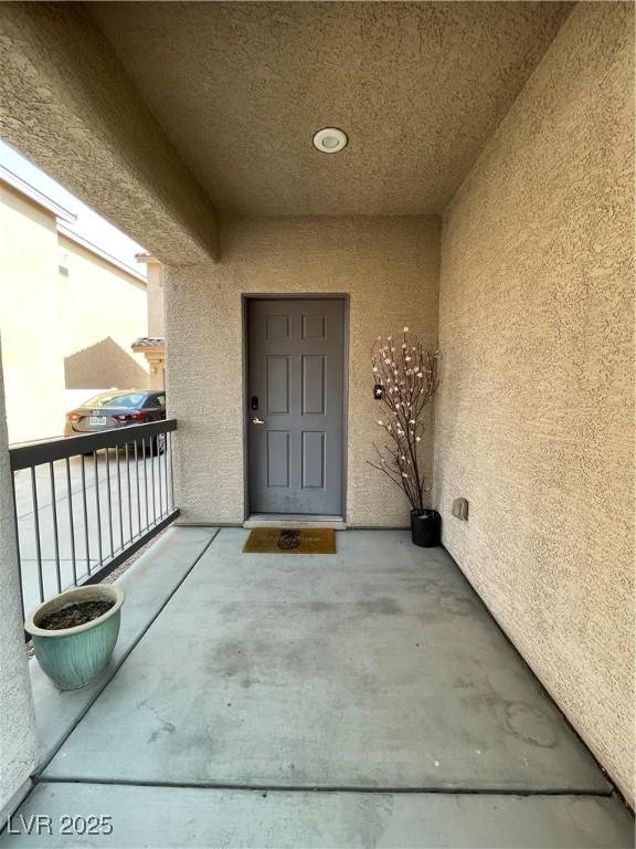 5625 Fast Payout Ct, Las Vegas, NV 89122 - property entrance with stucco siding and a balcony