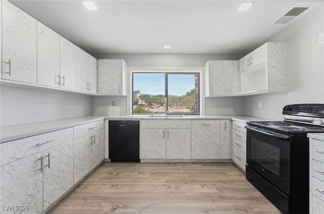 2222 N Martin L King Blvd, Las Vegas, NV 89106 - kitchen with black appliances, light wood-style flooring, light countertops, and white cabinets